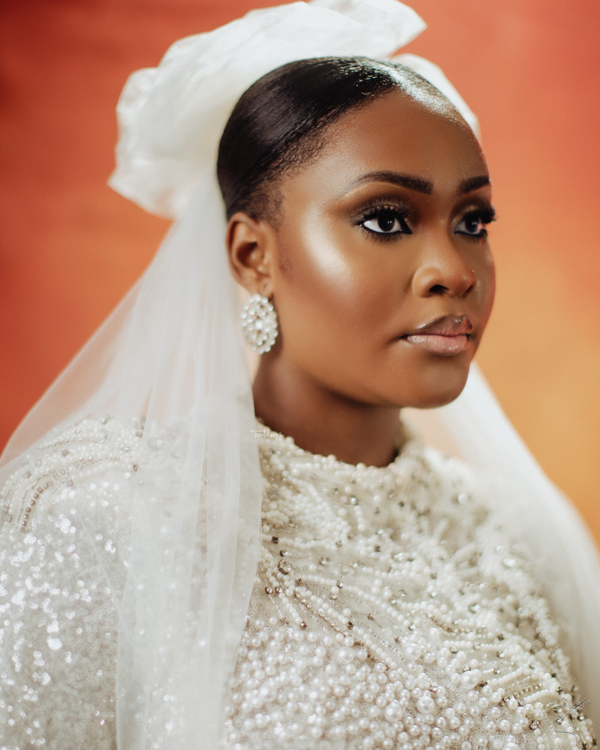 Close bridal portrait against a warm terracotta background