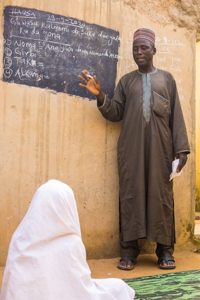 Teacher beside a chalkboard with children in the classroom