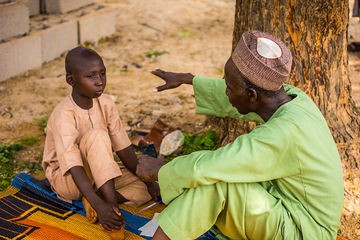 An intimate outdoor learning interaction between a child and an adult