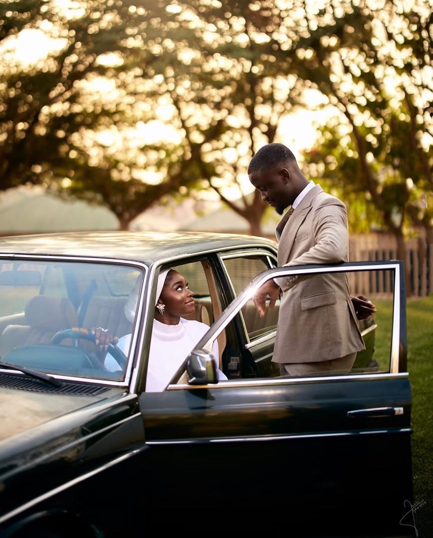 Couple sharing a moment beside an open classic car door