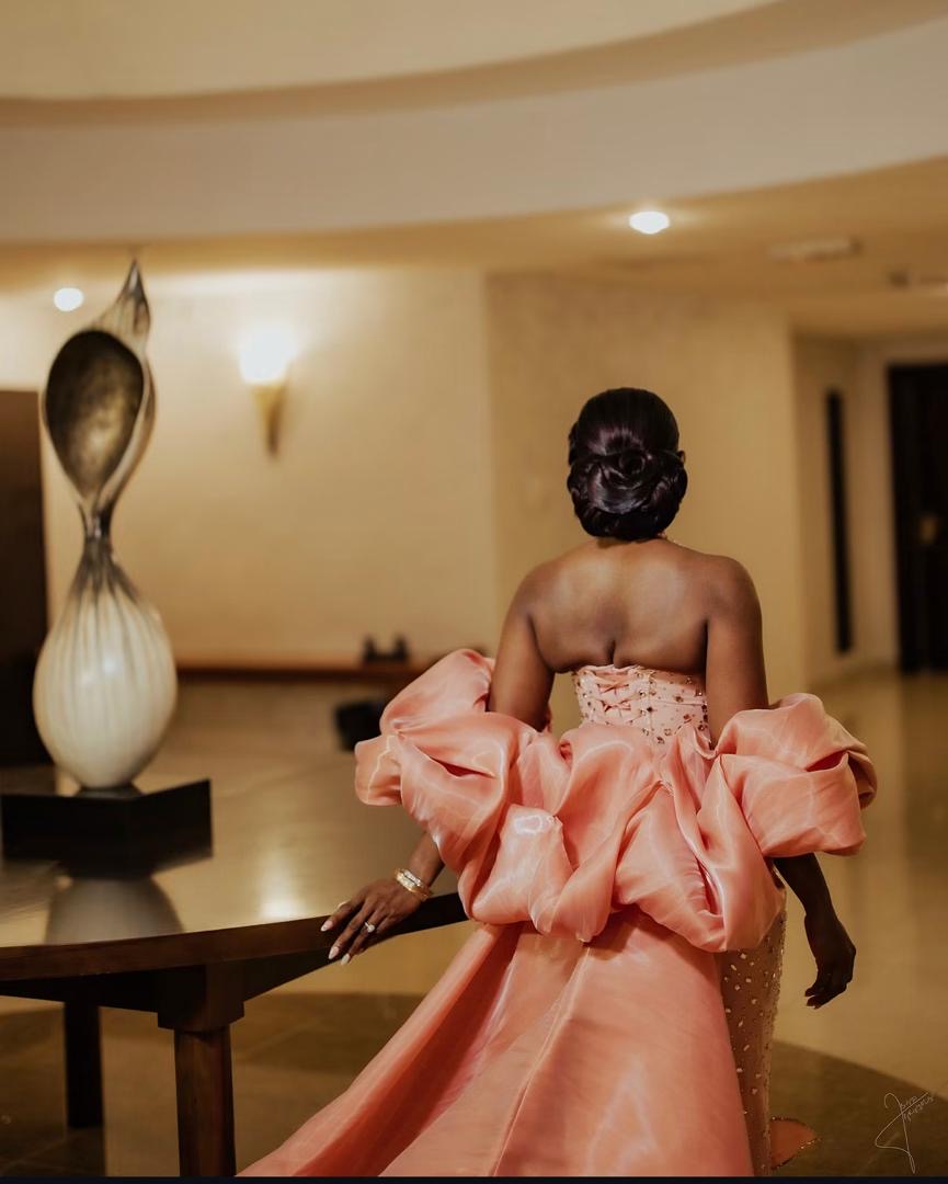 Woman in a flowing peach gown in an elegant interior
