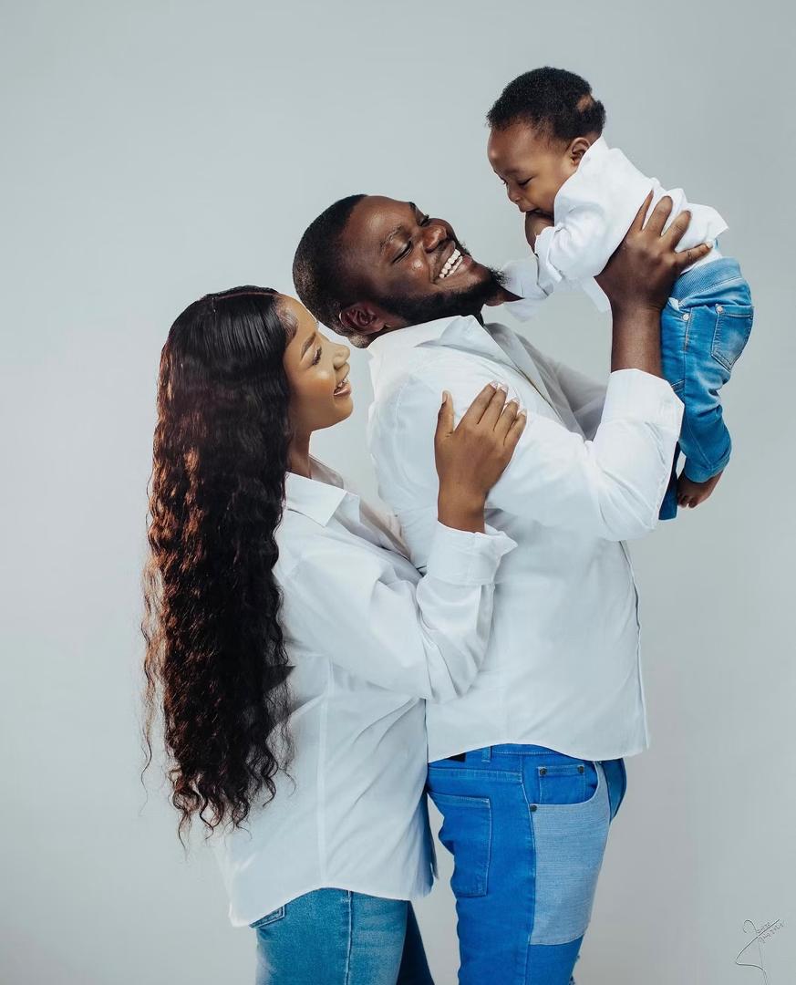 Parents sharing a joyful moment as the father lifts their baby