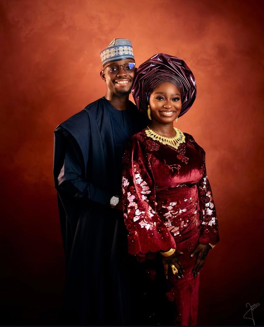 Smiling couple in navy and burgundy traditional wedding attire