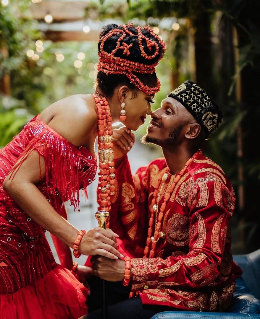 Couple in red traditional attire leaning close together